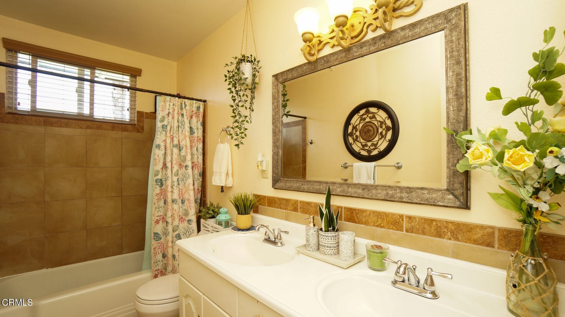 320 West Bard Road Oxnard, CA 93033 - Photo 12 of 21 a bathroom with a sink a toilet and a shower curtain