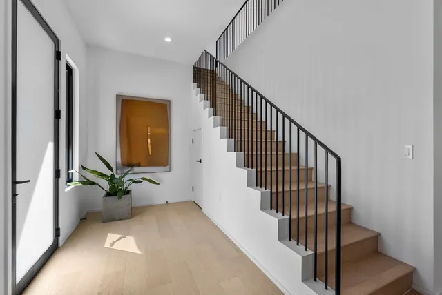 a view of a hallway with wooden floor and stairs