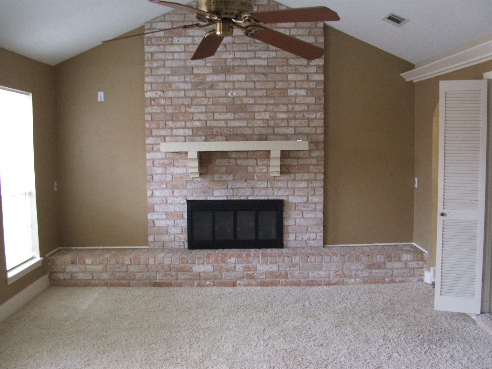 8231 Fernbrook Lane Houston, TX 77070 - Photo 3 of 12 a view of an empty room with a fireplace and a window
