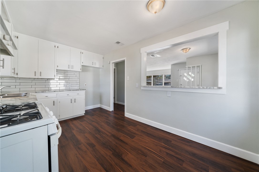826 Rosedale Drive Corpus Christi, TX 78411 - Photo 11 of 22 a kitchen with wooden floor and white cabinets