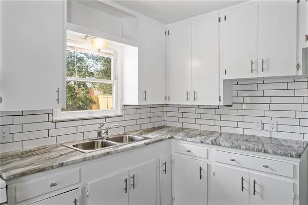 a kitchen with a sink cabinets and window