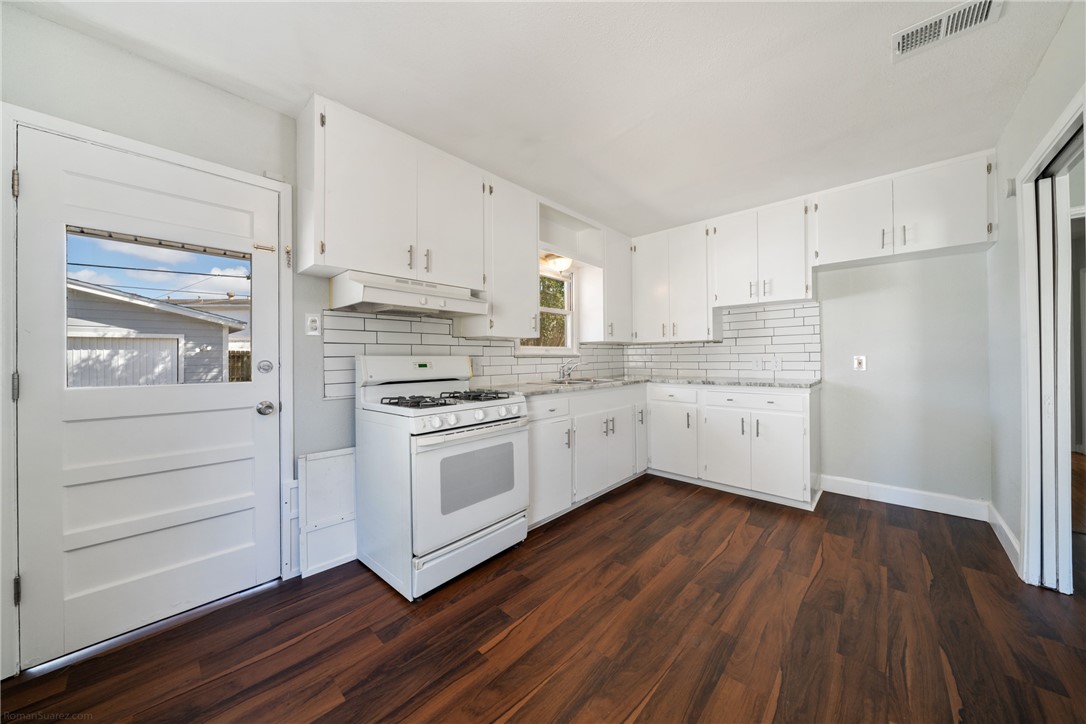 826 Rosedale Drive Corpus Christi, TX 78411 - Photo 10 of 22 a kitchen with stainless steel appliances a white cabinets and wooden floors