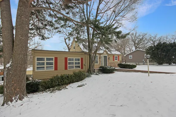 a front view of a house with a yard covered in snow