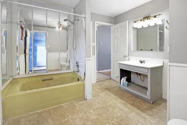 a spacious bathroom with a tub sink shower and mirror