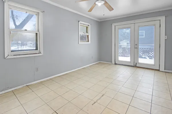 a view of an empty room with a window and kitchen view