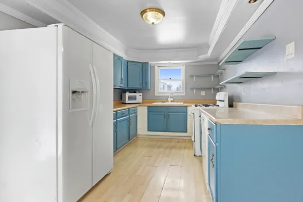 a kitchen with a sink a stove cabinets and a refrigerator