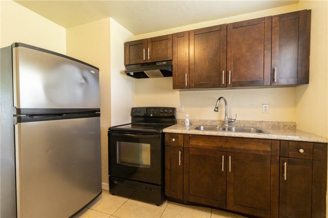 708 North 14th Street Fort Pierce, FL 34950 - Photo 8 of 12 a kitchen with a sink and a refrigerator