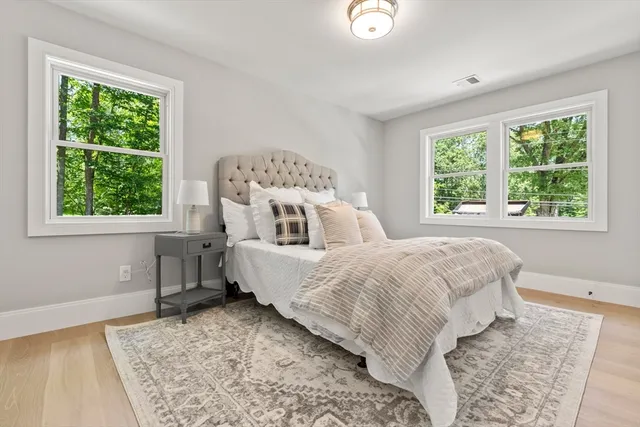 a large bed sitting in a bedroom next to a window