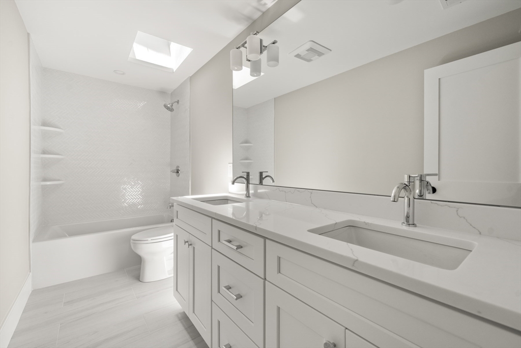 2 Rockwood Road Natick, MA 01760 - Photo 19 of 37 a bathroom with a double vanity sink mirror double and a bathtub