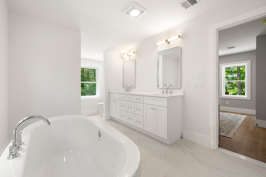 2 Rockwood Road Natick, MA 01760 - Photo 26 of 37 a spacious bathroom with a double vanity sink a mirror and a bathtub