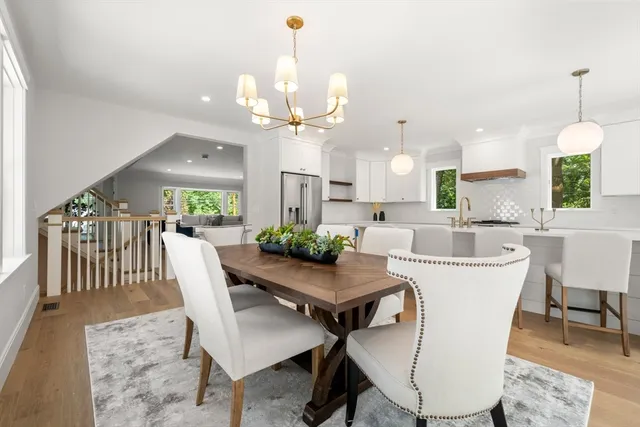 a kitchen with sink stove and white cabinets with wooden floor