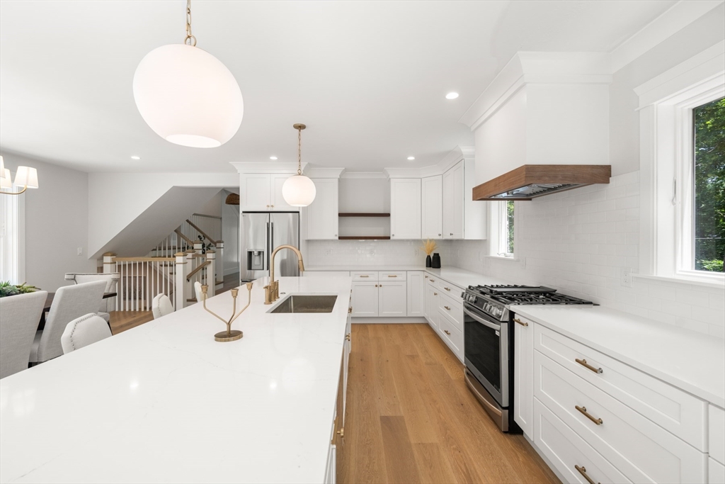 2 Rockwood Road Natick, MA 01760 - Photo 7 of 37 a kitchen with stainless steel appliances kitchen island granite countertop a stove a sink a refrigerator and white cabinets with wooden floor