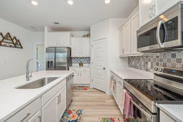 a kitchen with stainless steel appliances granite countertop a sink stove and refrigerator
