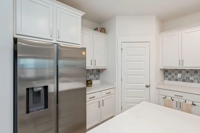 a kitchen with cabinets and a refrigerator