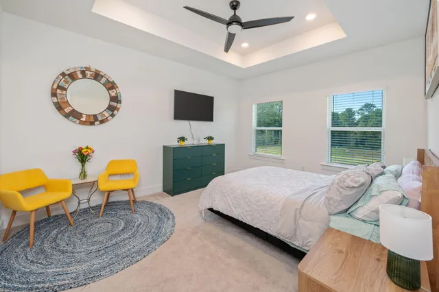 a living room with furniture a flat screen tv and a large window
