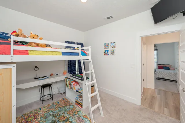 a room with a baby bed a couch and a dresser