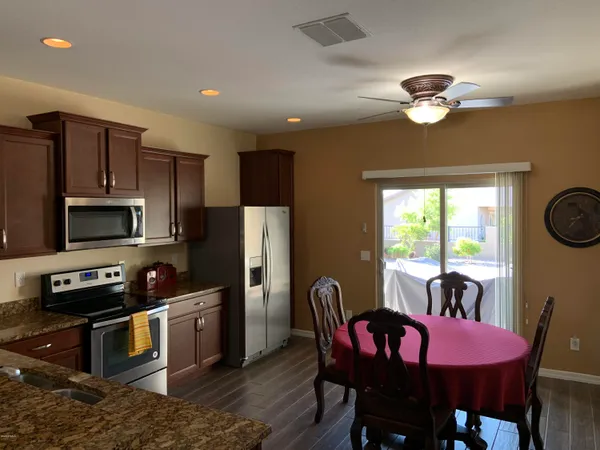 a kitchen with stainless steel appliances granite countertop a dining table and chairs