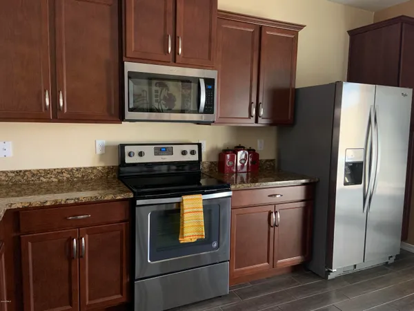 a kitchen with stainless steel appliances granite countertop a refrigerator stove and microwave