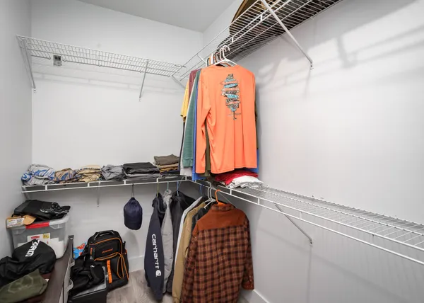 a view of walk in closet with clothes and shoes