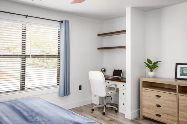 a view of a workspace with furniture and a window