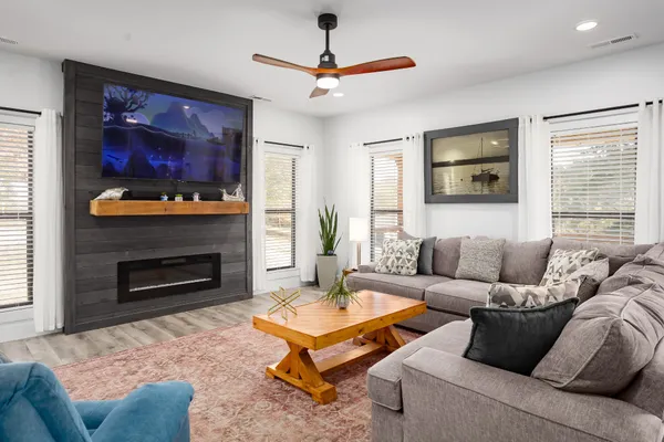 a living room with furniture a flat screen tv and a fireplace