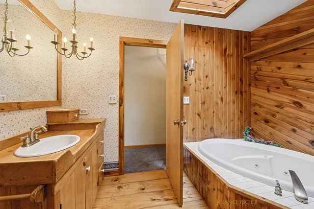 a bathroom with a tub a sink and a mirror
