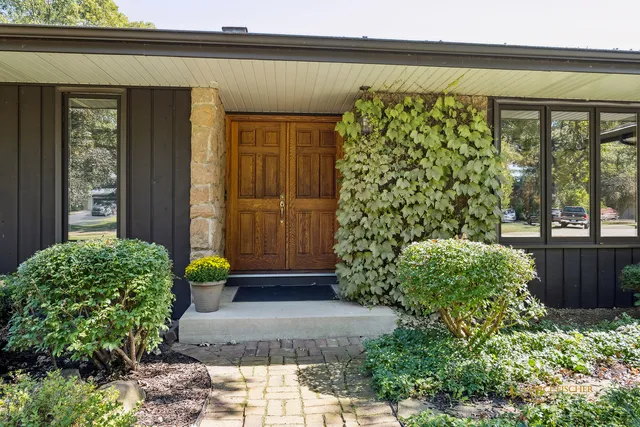a view of a entryway door of the house with potted plants