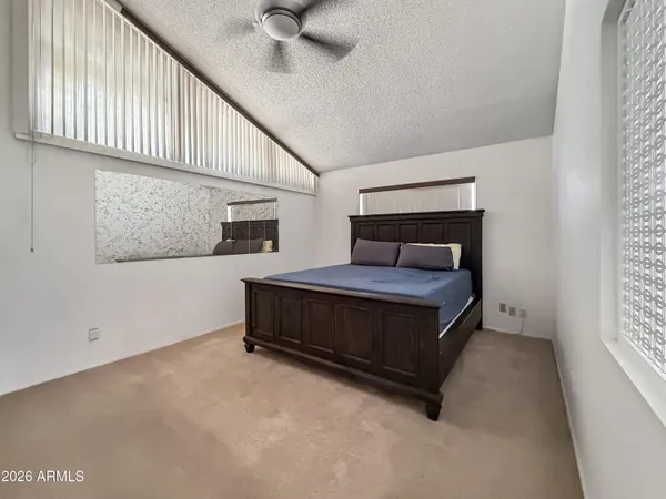 a bedroom with a bed and a ceiling fan