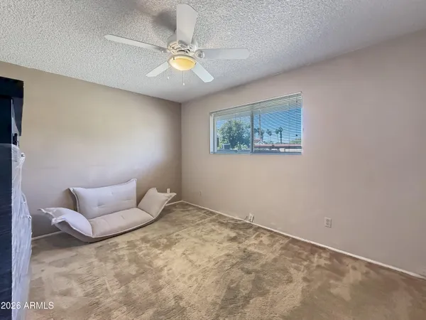 a bedroom with a bed and painting on the wall