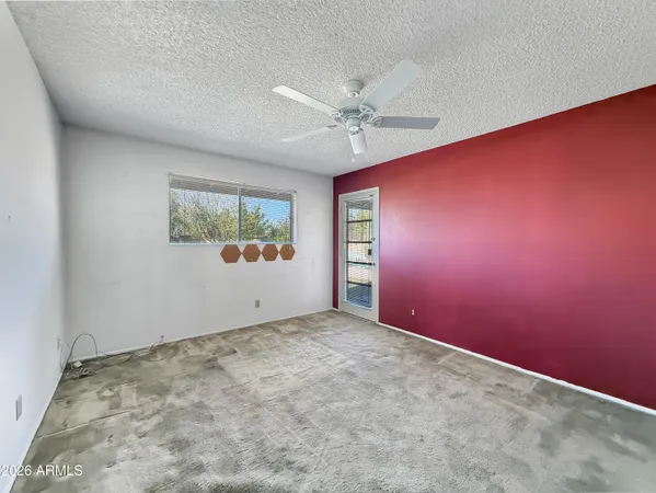 an empty room with windows and fan