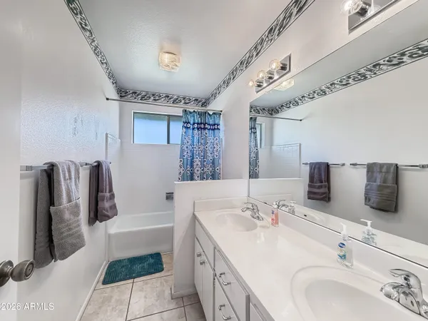 a spacious bathroom with a tub sink and mirror