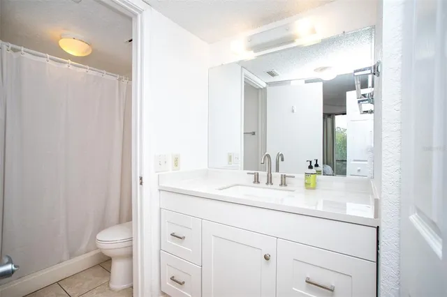 a bathroom with a granite countertop toilet sink and a mirror