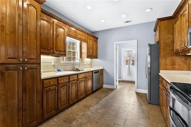 a view of a hallway with wooden floor and a bathroom