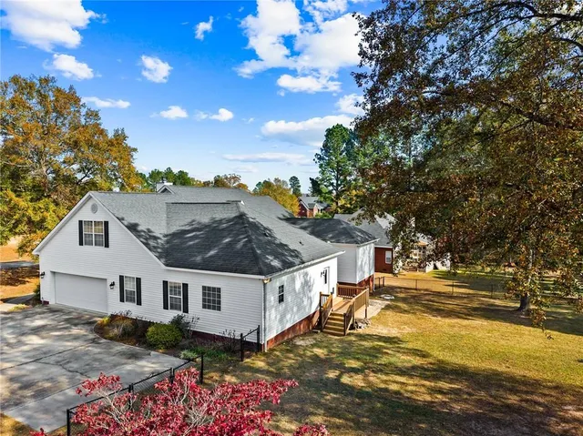a view of a house with a big yard and large tree