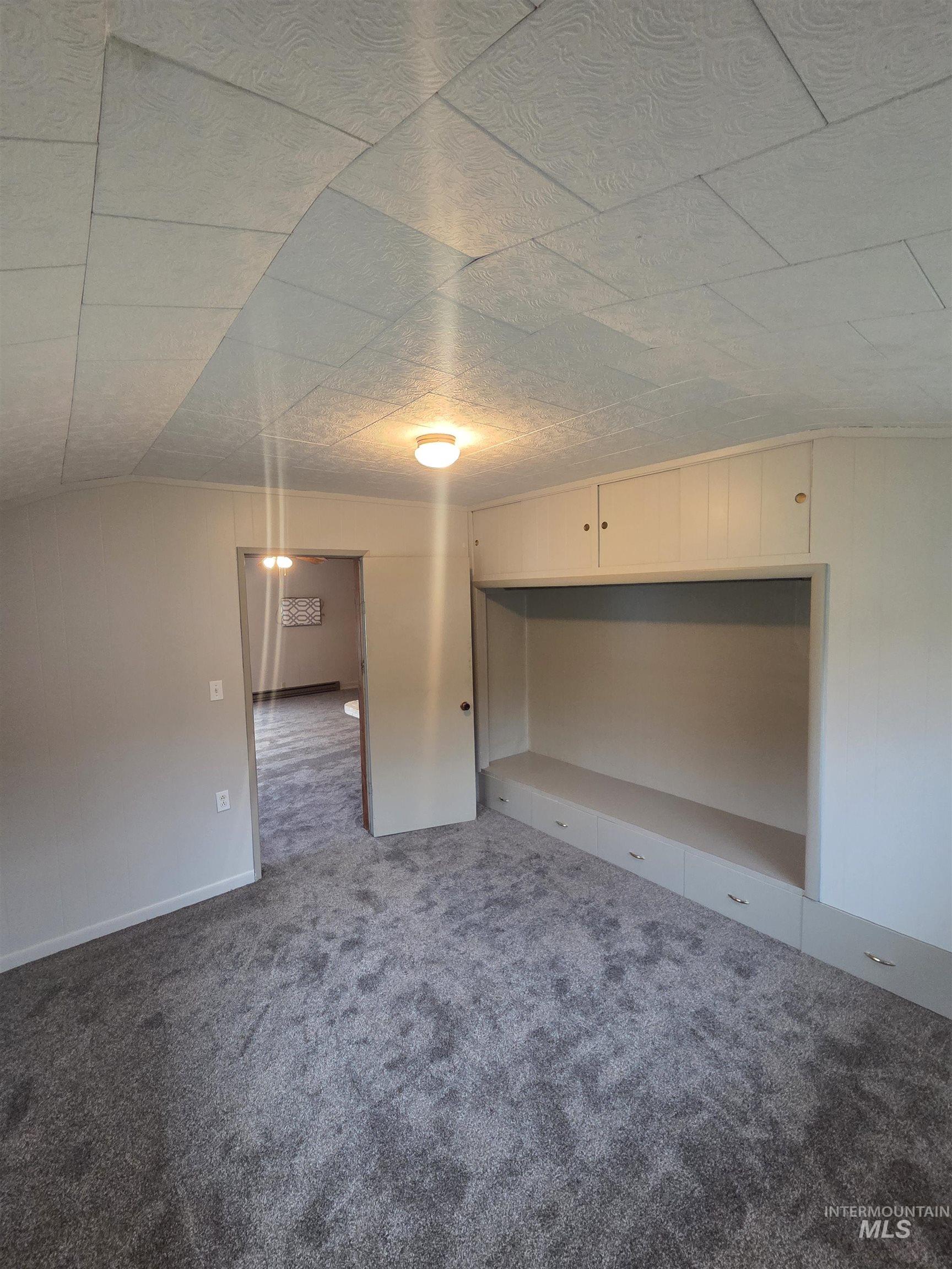 465 South 15th Street Pomeroy, WA 99347 - Photo 19 of 24 Spare room featuring dark colored carpet and vaulted ceiling