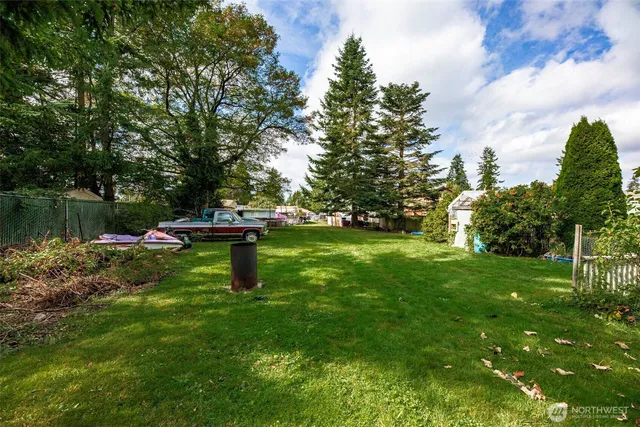 an aerial view of a residential apartment building with a yard and parking spaces