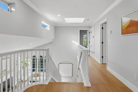 a view of a hallway with wooden floor and staircase