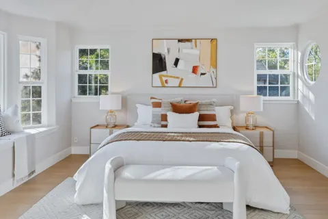 a bedroom with a bed and windows