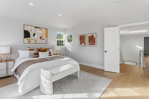 a bedroom with a bed and painting on the wall