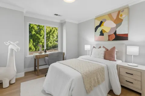 a bedroom with a bed and a painting on the wall