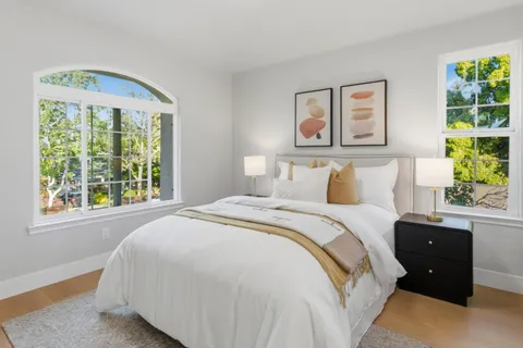 a bedroom with a bed and a large window