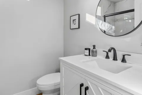 a bathroom with a sink a toilet and a mirror