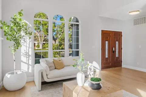 a living room with patio furniture and a potted plant