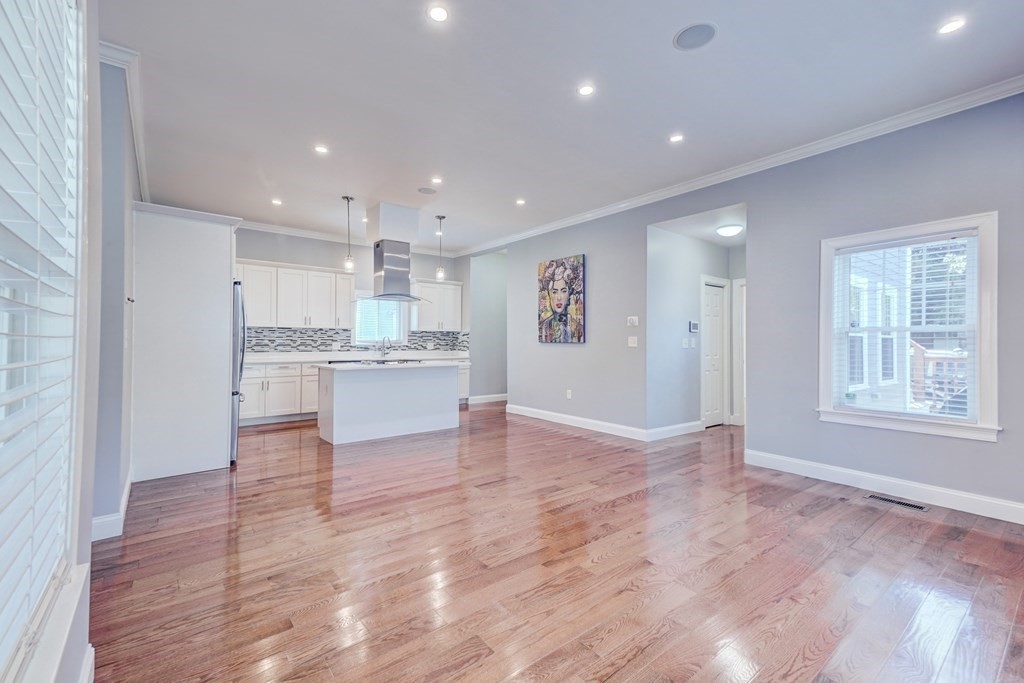 1008-1010 River Street, Unit 1 Boston, MA 02136 - Photo 13 of 29 a view of a kitchen with kitchen island a sink wooden floor and a refrigerator