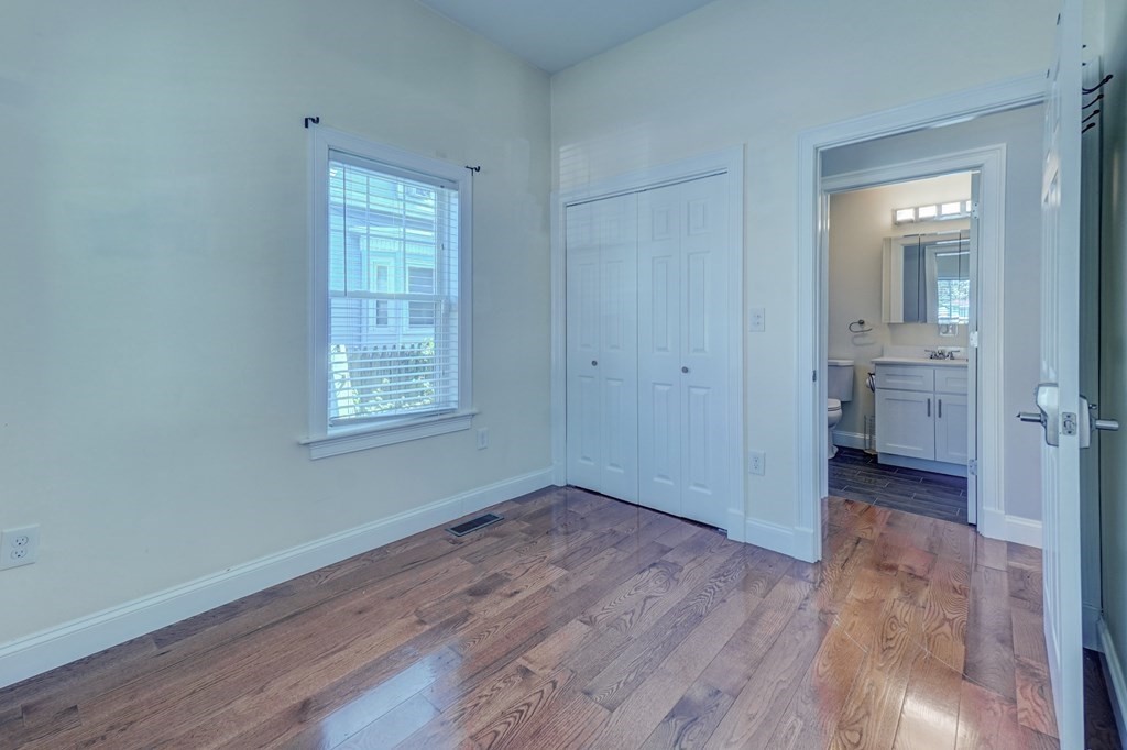 1008-1010 River Street, Unit 1 Boston, MA 02136 - Photo 19 of 29 wooden floor in an empty room with a window
