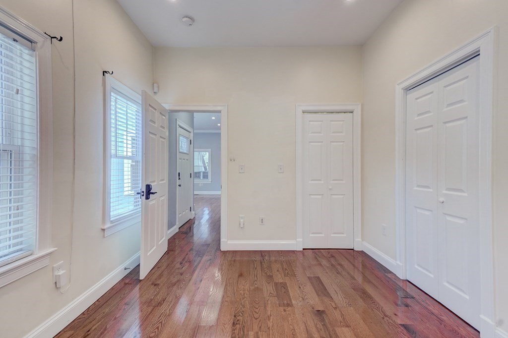 1008-1010 River Street, Unit 1 Boston, MA 02136 - Photo 21 of 29 an empty room with wooden floor and windows
