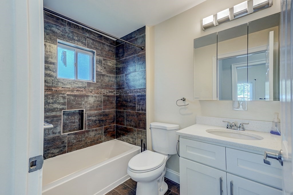 1008-1010 River Street, Unit 1 Boston, MA 02136 - Photo 23 of 29 a bathroom with a sink toilet bathtub and mirror