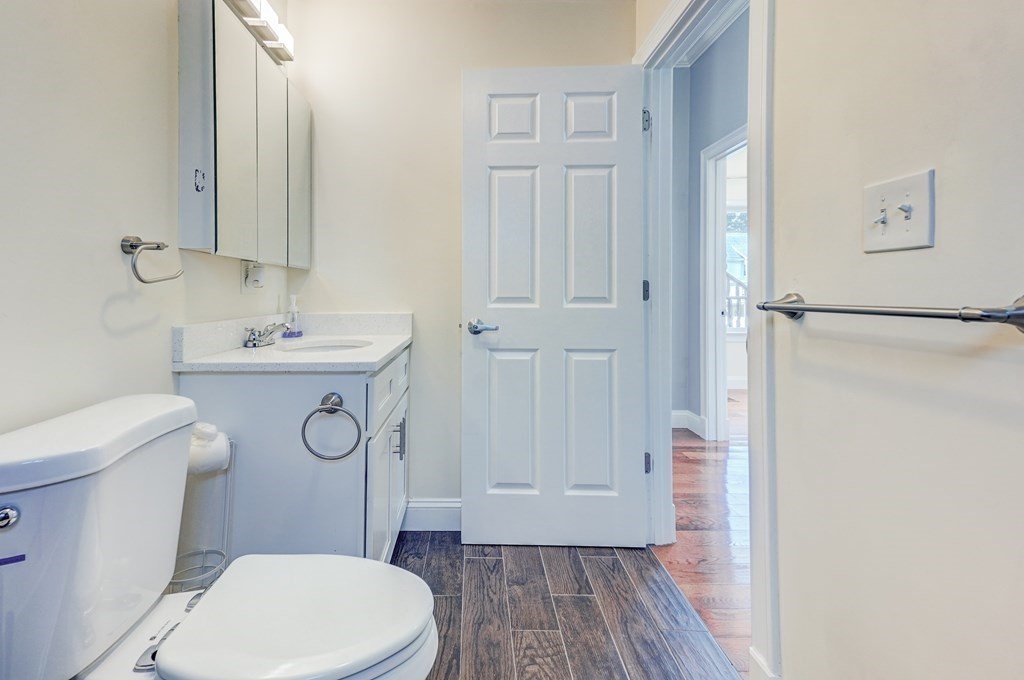 1008-1010 River Street, Unit 1 Boston, MA 02136 - Photo 24 of 29 a bathroom with a sink a toilet a mirror and vanity