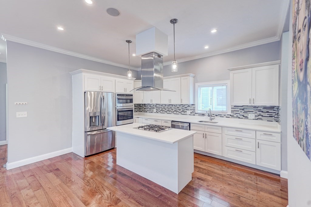 1008-1010 River Street, Unit 1 Boston, MA 02136 - Photo 5 of 29 a kitchen with kitchen island a sink stainless steel appliances and cabinets