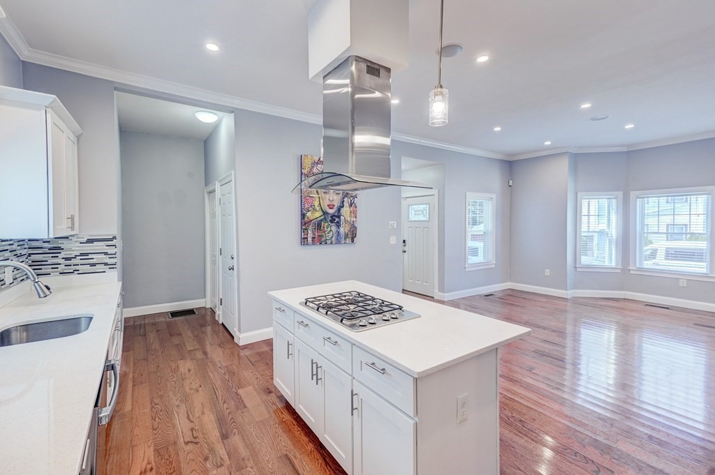 1008-1010 River Street, Unit 1 Boston, MA 02136 - Photo 7 of 29 a kitchen with a sink a stove a refrigerator and white cabinets with wooden floor